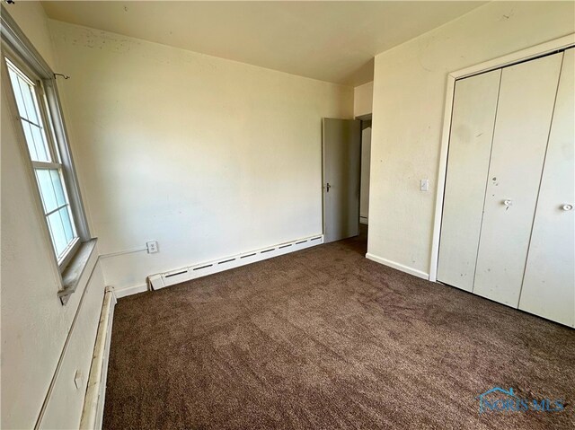 4865 296th St, Toledo, OH 43611 - unfurnished bedroom with a closet, baseboard heating, and carpet floors