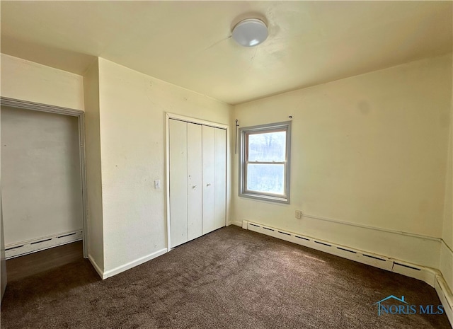 4865 296th St, Toledo, OH 43611 - unfurnished bedroom with baseboard heating, dark colored carpet, a closet, and baseboards