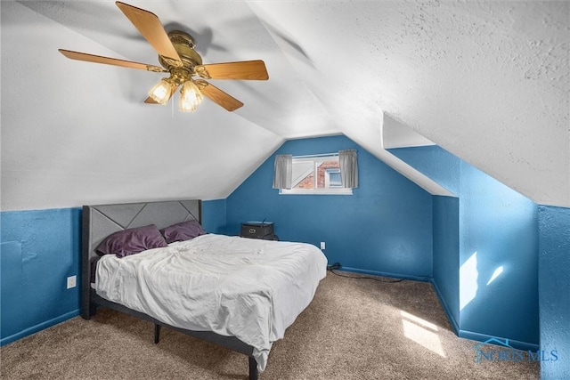 carpeted bedroom with a textured ceiling, a ceiling fan, vaulted ceiling, and baseboards