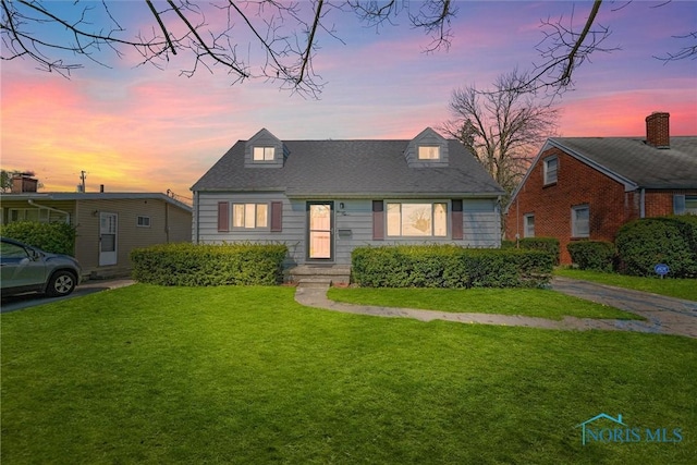 cape cod home with a front lawn