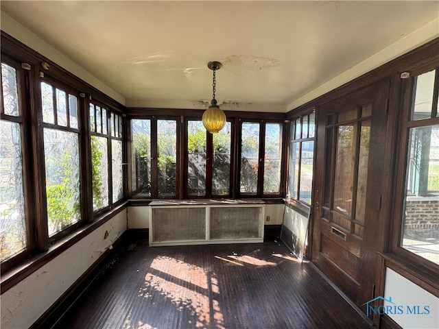 unfurnished sunroom featuring wood-type flooring, french doors, and baseboards
