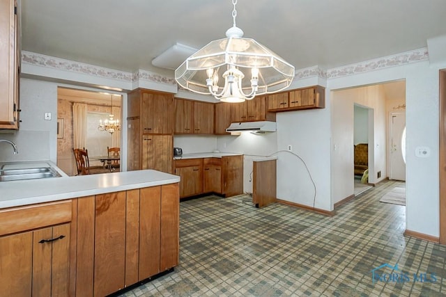 400 Orchard View Dr, Maumee, OH 43537 - kitchen featuring a chandelier, a sink, under cabinet range hood, a peninsula, and brown cabinetry