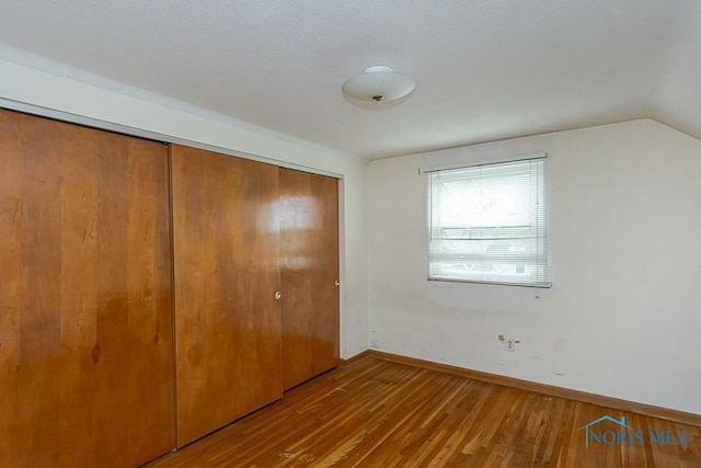 400 Orchard View Dr, Maumee, OH 43537 - unfurnished bedroom featuring a closet, wood finished floors, baseboards, and lofted ceiling