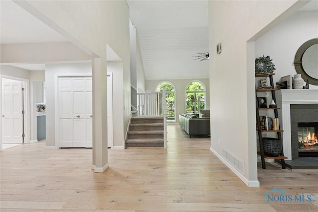 544 Jacqueline Ct, Holland, OH 43528 - foyer with a glass covered fireplace, light wood-style floors, stairs, baseboards, and a high ceiling