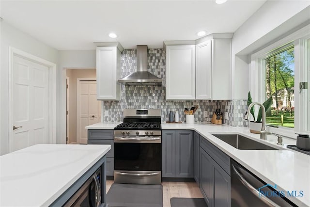 544 Jacqueline Ct, Holland, OH 43528 - kitchen featuring appliances with stainless steel finishes, wall chimney range hood, a sink, light countertops, and recessed lighting