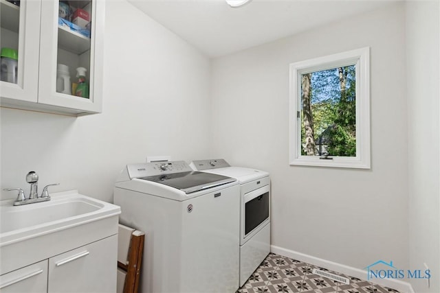 544 Jacqueline Ct, Holland, OH 43528 - laundry area featuring cabinet space, washing machine and dryer, baseboards, and light floors