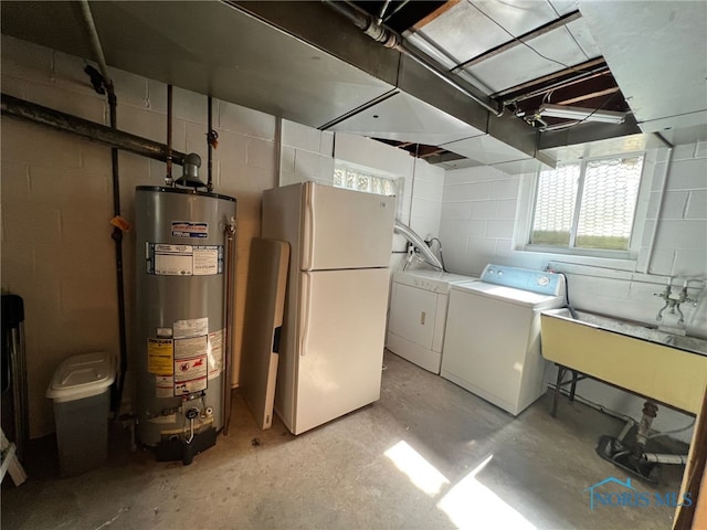 below grade area with gas water heater, a sink, freestanding refrigerator, and washing machine and dryer