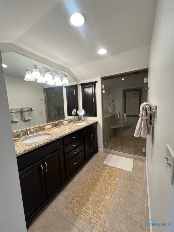 full bathroom with vaulted ceiling, a stall shower, double vanity, and a sink