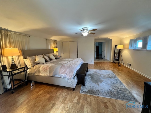 bedroom featuring wood finished floors, visible vents, a ceiling fan, and baseboards