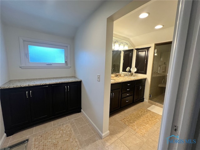full bath with vanity, tile patterned floors, a stall shower, baseboards, and lofted ceiling