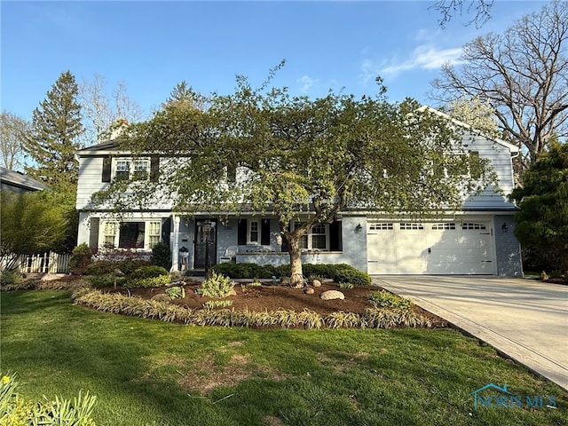 view of front of home with a front yard, driveway, and an attached garage