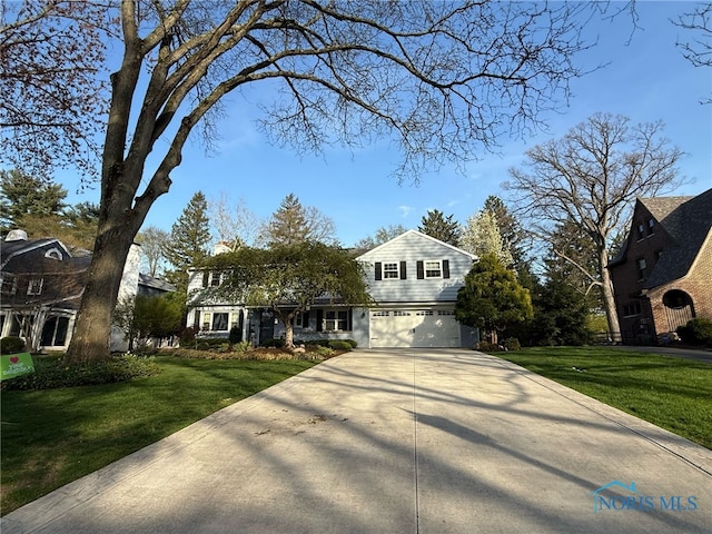 traditional-style house with a garage, a front lawn, and concrete driveway