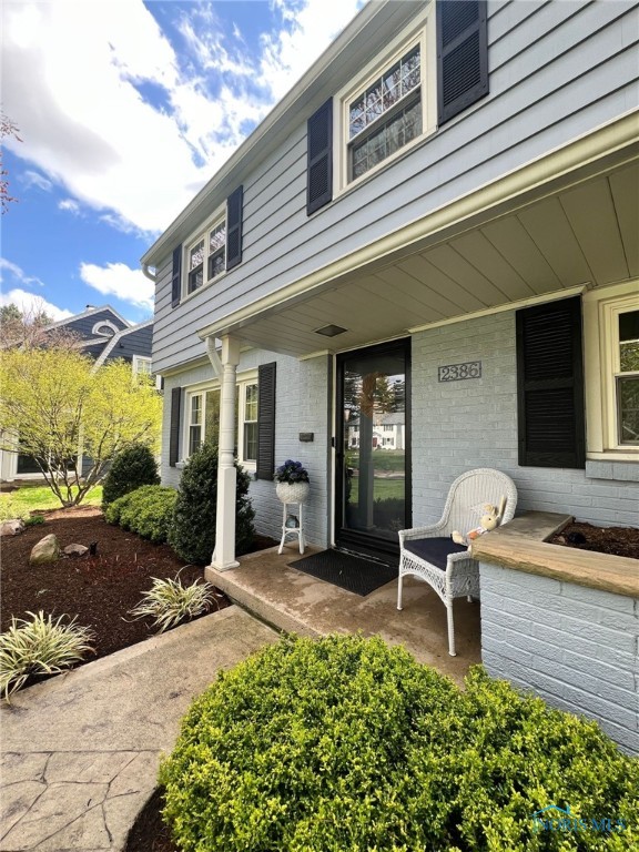 entrance to property featuring brick siding and a porch
