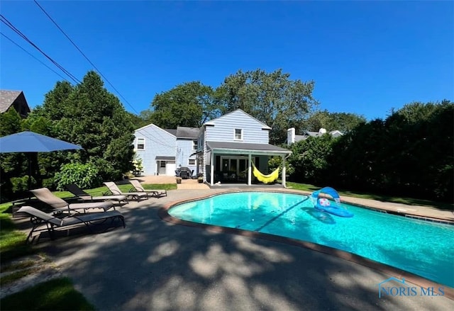 outdoor pool with a patio area