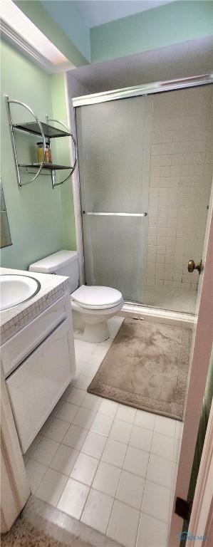 1773 Valley Way Dr, Toledo, OH 43614 - bathroom featuring vanity, toilet, a stall shower, and tile patterned flooring