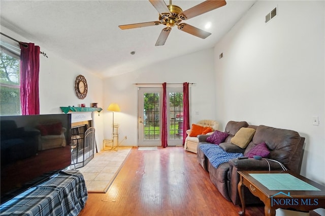 705 Reineck Dr, Toledo, OH 43605 - living area with ceiling fan, visible vents, vaulted ceiling, a tile fireplace, and wood finished floors