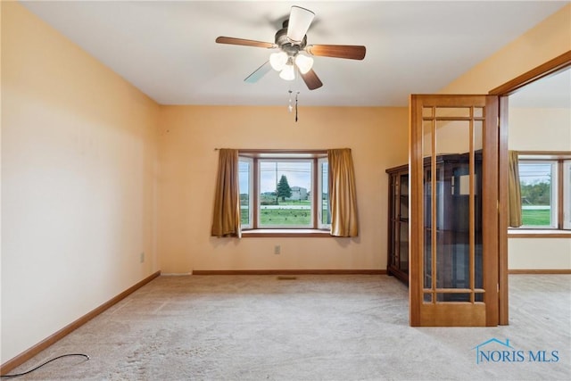 unfurnished room featuring carpet floors, baseboards, and ceiling fan
