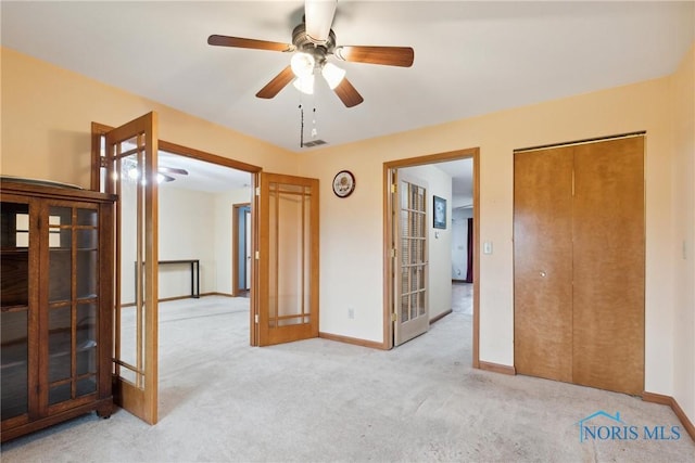 empty room featuring baseboards, carpet flooring, and a ceiling fan