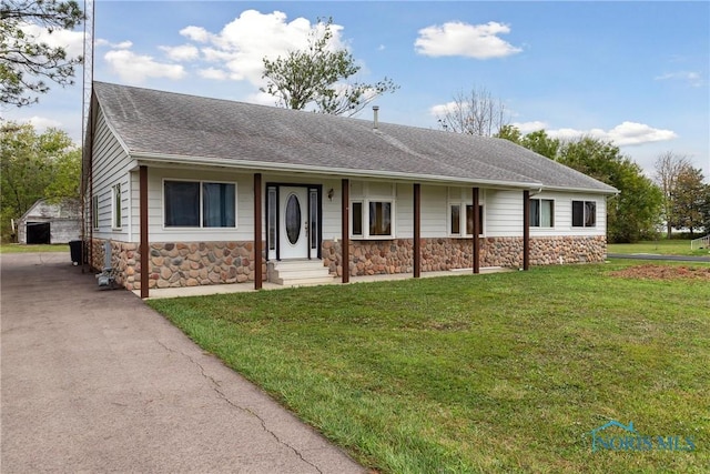 ranch-style home with roof with shingles, a front lawn, and stone siding