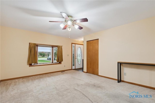 spare room with carpet floors, ceiling fan, and baseboards