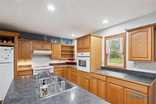 kitchen featuring open shelves, dark countertops, a sink, white appliances, and under cabinet range hood