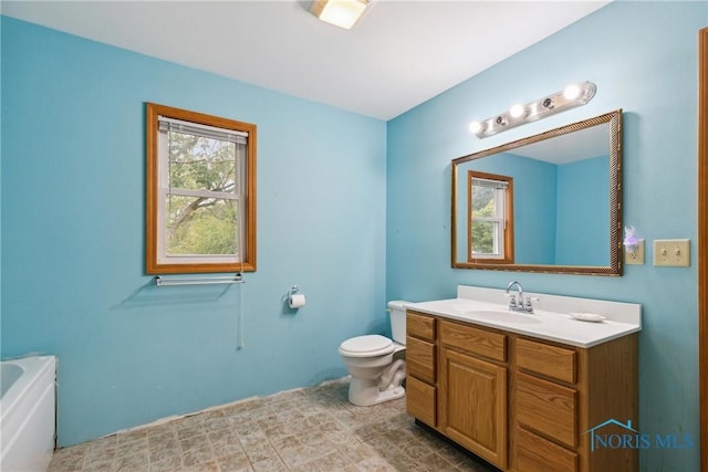 bathroom featuring toilet, a bath, and vanity