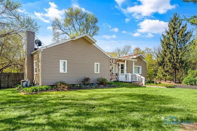 back of property with a yard, fence, and a chimney