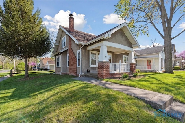 326 E Dudley St, Maumee, OH 43537 - view of front of property featuring a porch, a chimney, a front yard, brick siding, and stucco siding