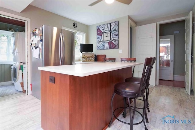202 Hancock St, Findlay, OH 45840 - kitchen with stacked washer / dryer, light countertops, a kitchen breakfast bar, a ceiling fan, and baseboards