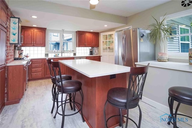 202 Hancock St, Findlay, OH 45840 - kitchen featuring a breakfast bar area, stainless steel appliances, a center island, light countertops, and a sink