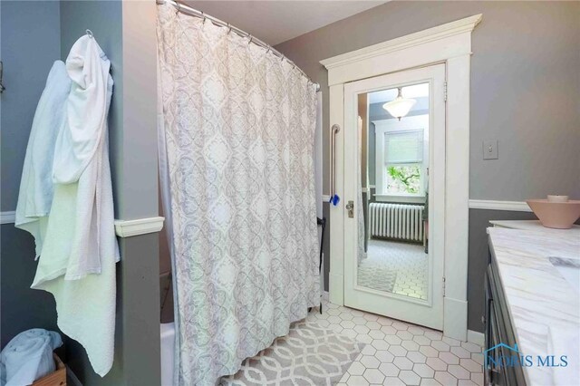 202 Hancock St, Findlay, OH 45840 - bathroom featuring radiator, vanity, shower / bathtub combination with curtain, and tile patterned flooring