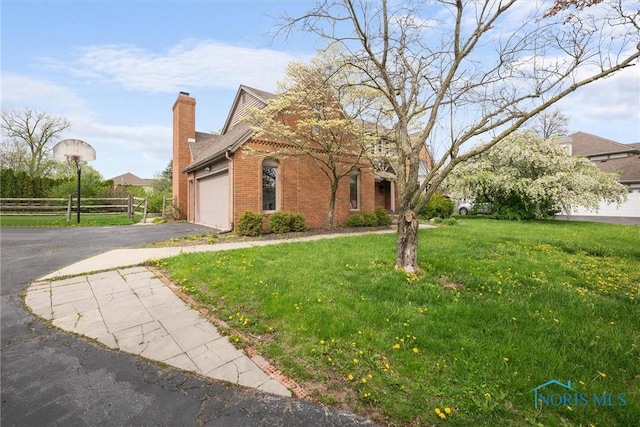 6142 Welsford Ct, Maumee, OH 43537 - view of front of house with fence, aphalt driveway, a garage, brick siding, and a chimney
