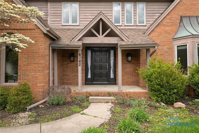 6142 Welsford Ct, Maumee, OH 43537 - property entrance featuring roof with shingles and brick siding