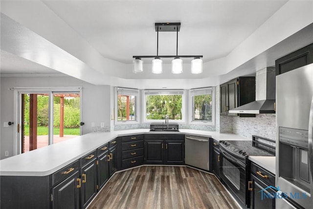 6142 Welsford Ct, Maumee, OH 43537 - kitchen with wall chimney range hood, a sink, light countertops, stainless steel appliances, and a peninsula