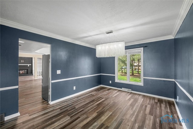 6142 Welsford Ct, Maumee, OH 43537 - spare room featuring visible vents, crown molding, wood finished floors, baseboards, and a notable chandelier