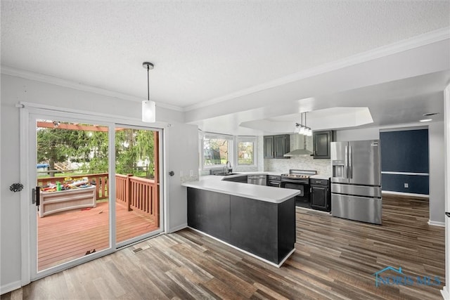 6142 Welsford Ct, Maumee, OH 43537 - kitchen featuring dark wood-style flooring, appliances with stainless steel finishes, light countertops, a peninsula, and wall chimney exhaust hood