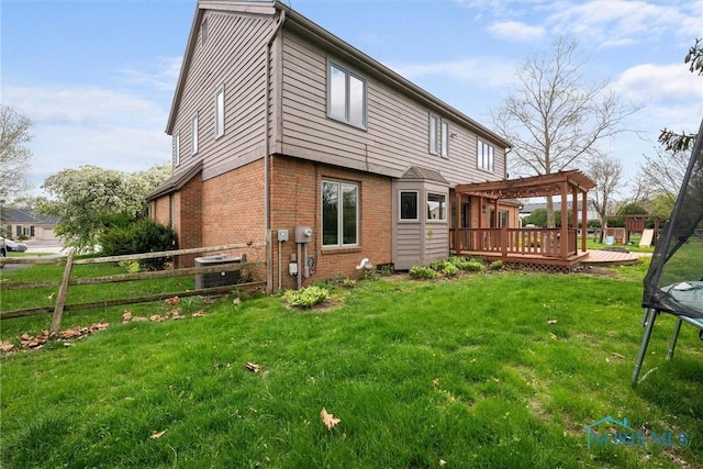 6142 Welsford Ct, Maumee, OH 43537 - back of property featuring fence, a trampoline, a pergola, brick siding, and a deck