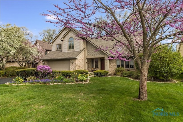 traditional-style house featuring a garage, brick siding, roof with shingles, and a front yard