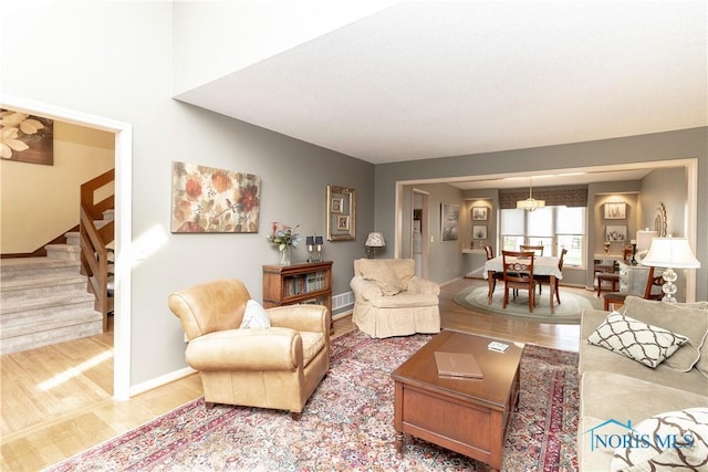 living room featuring baseboards, stairs, and wood finished floors