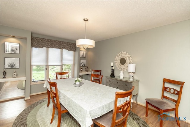 dining space featuring baseboards and wood finished floors