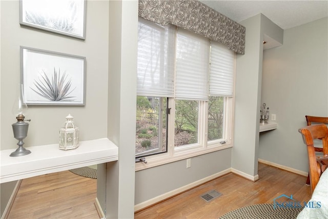 interior space featuring baseboards, visible vents, and wood finished floors