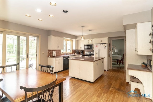 kitchen featuring a kitchen island, recessed lighting, a sink, backsplash, and stainless steel appliances