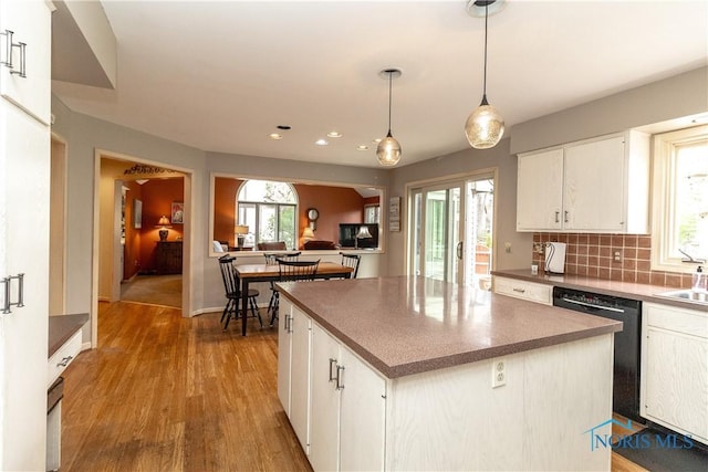 kitchen with tasteful backsplash, wood finished floors, dishwasher, white cabinets, and recessed lighting