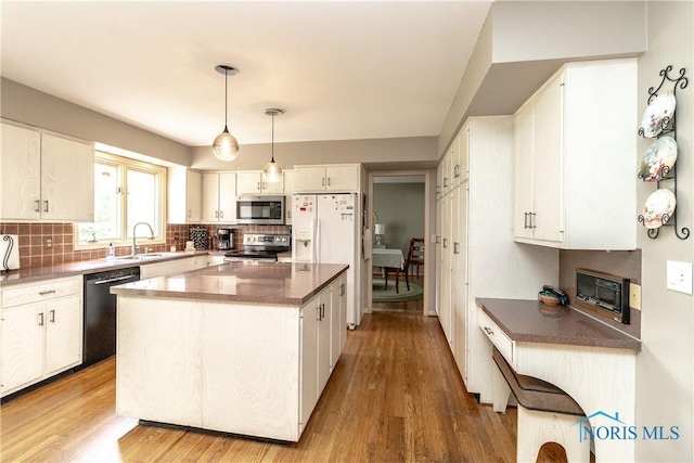 kitchen featuring light wood-type flooring, backsplash, and stainless steel appliances