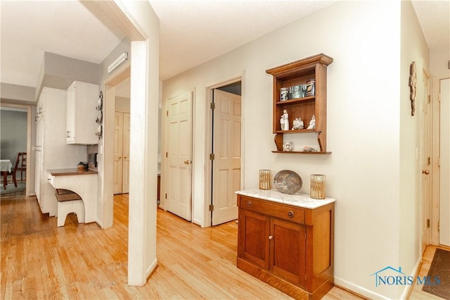 hallway with baseboards and light wood-style floors