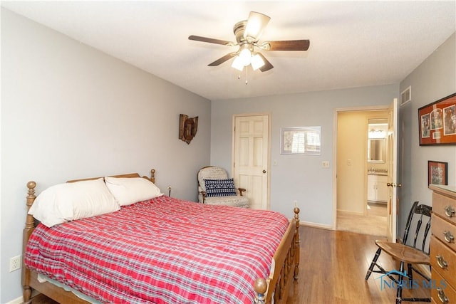 bedroom featuring baseboards, ceiling fan, wood finished floors, and visible vents