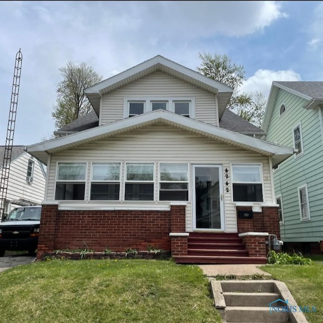 4242 Fairview Dr, Toledo, OH 43612 - bungalow with entry steps, brick siding, a front lawn, and a shingled roof