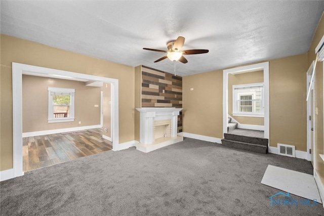 4242 Fairview Dr, Toledo, OH 43612 - unfurnished living room with ceiling fan, carpet floors, stairs, baseboards, and a fireplace with raised hearth