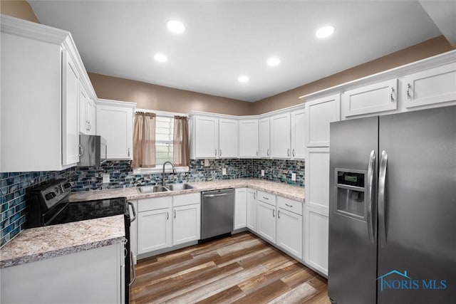 4242 Fairview Dr, Toledo, OH 43612 - kitchen featuring stainless steel appliances, a sink, decorative backsplash, white cabinets, and recessed lighting