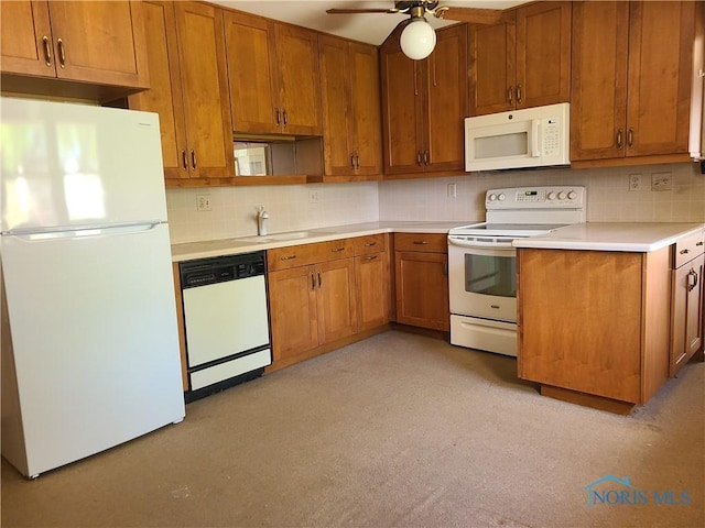kitchen with light countertops, brown cabinets, backsplash, and white appliances